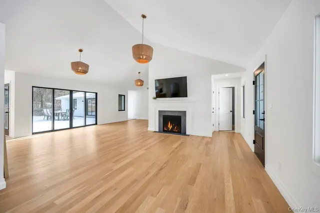 a view of empty room with wooden floor and window