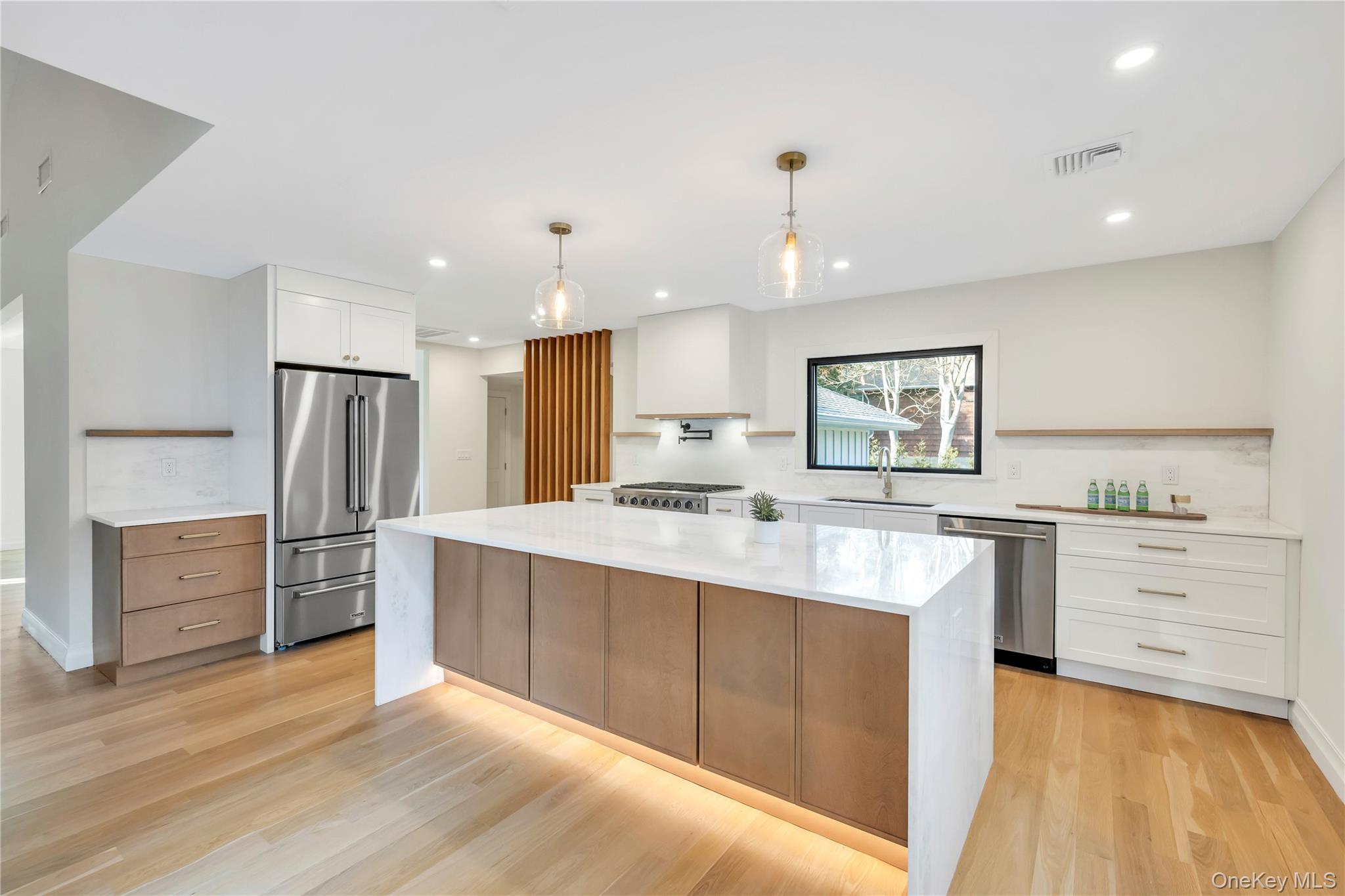 10 Lenape Road Southampton, NY 11968 - Photo 5 of 16 Kitchen featuring white cabinets, light stone countertops, stainless steel appliances, decorative light fixtures, and recessed lighting