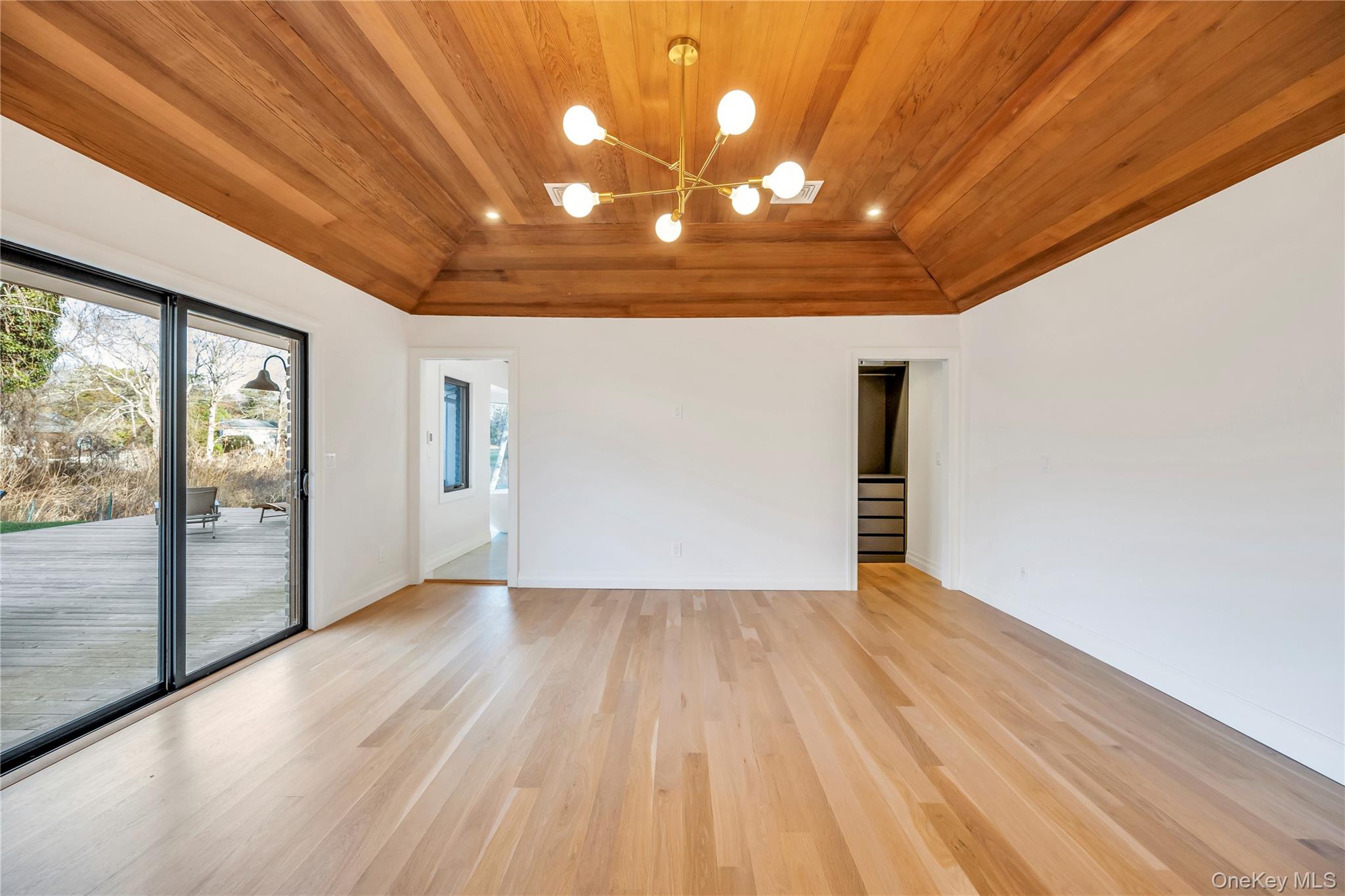 10 Lenape Road Southampton, NY 11968 - Photo 8 of 16 Unfurnished room featuring vaulted ceiling, wooden ceiling, a chandelier, and light wood-type flooring
