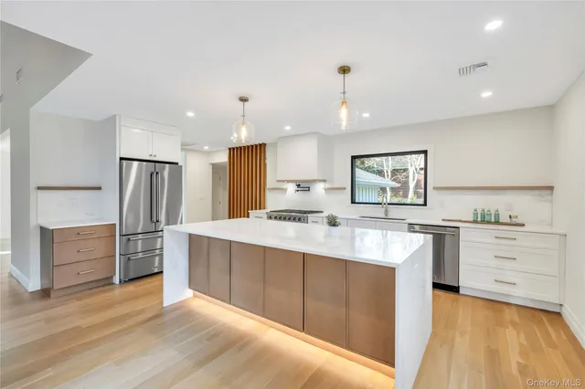 a large white kitchen with a stove top oven a sink a counter space and cabinets