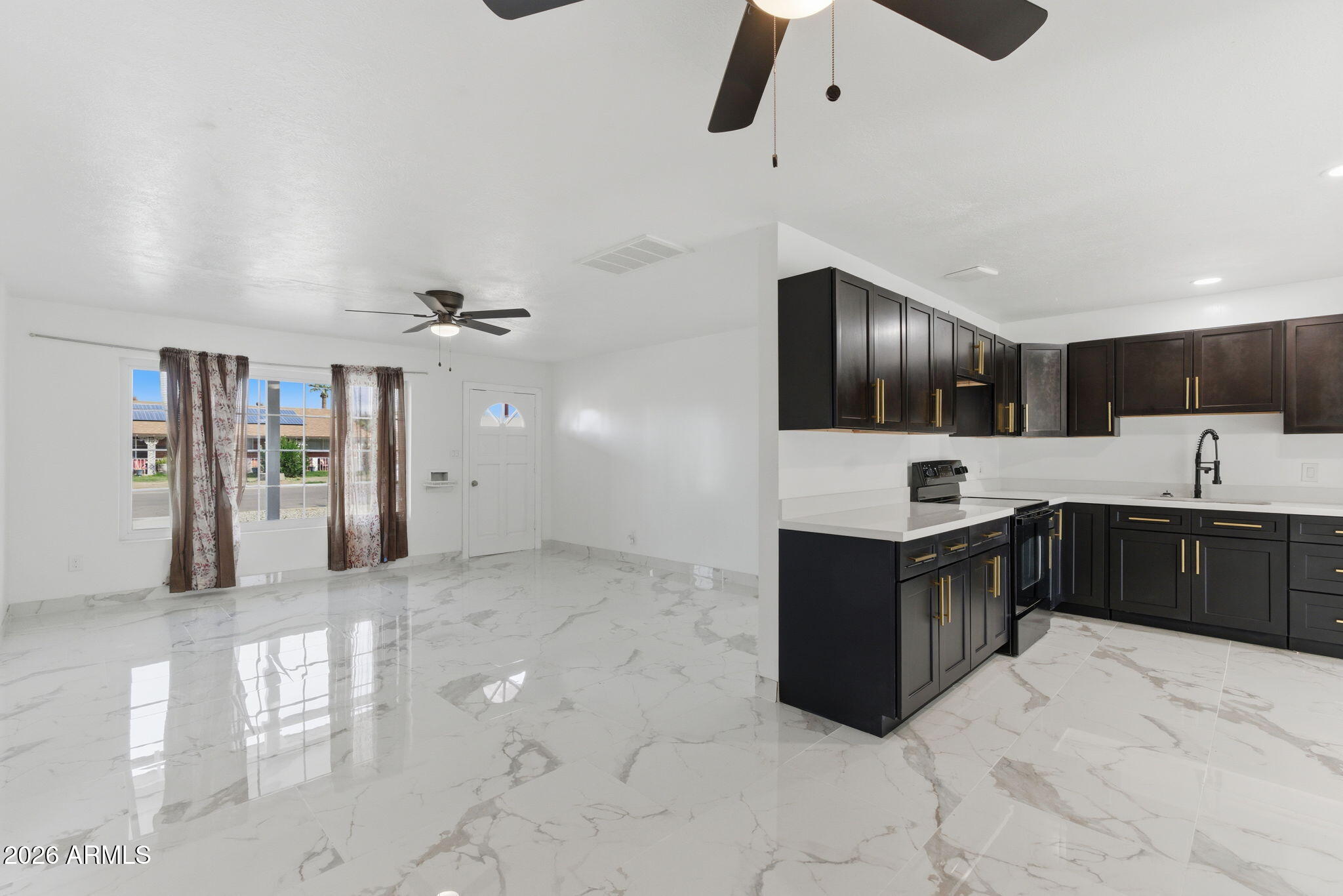 4251 West Rose Lane Phoenix, AZ 85019 - Photo 4 of 24 a large kitchen with stainless steel appliances kitchen island granite countertop a refrigerator and a sink