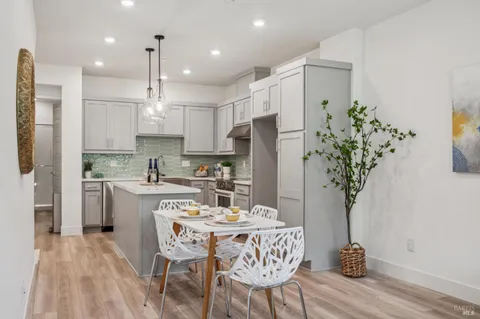 a living room with furniture and a dining table with kitchen view