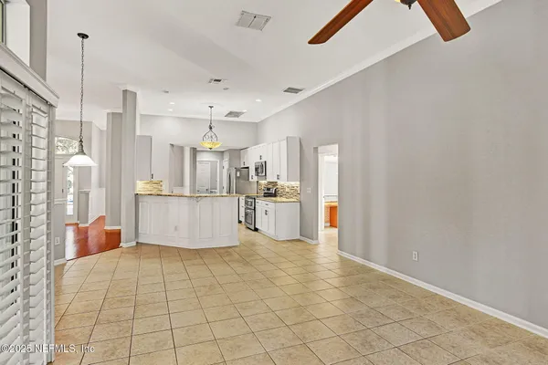 a view of a kitchen with furniture and refrigerator