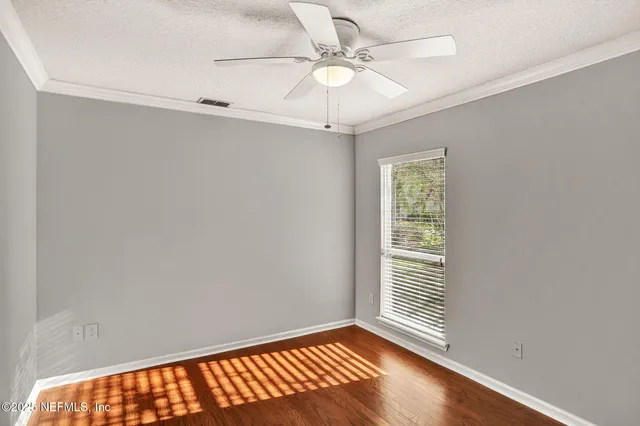 a view of a room with a window and a ceiling fan