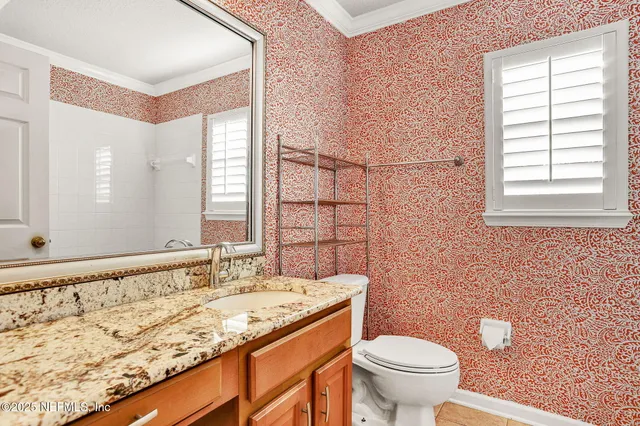 a bathroom with a granite countertop sink a toilet and a mirror