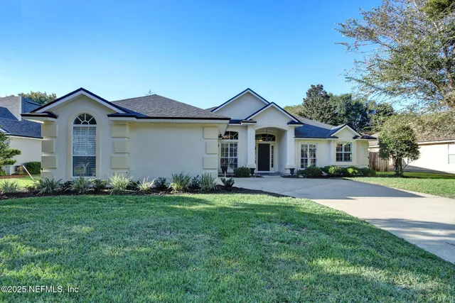 a front view of a house with a garden and yard