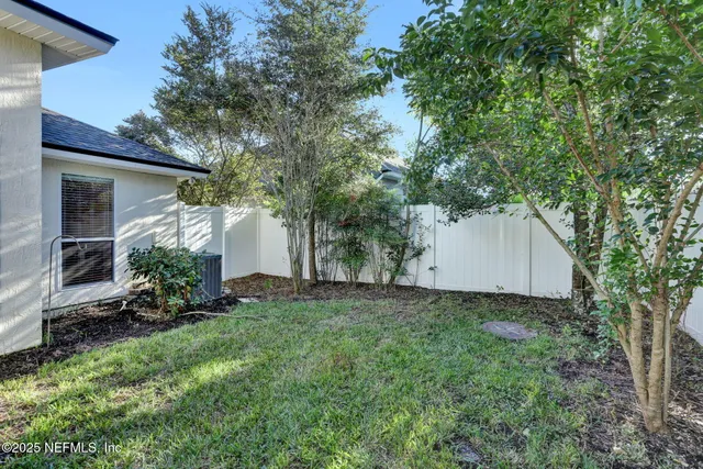 a view of a house with a yard and large tree