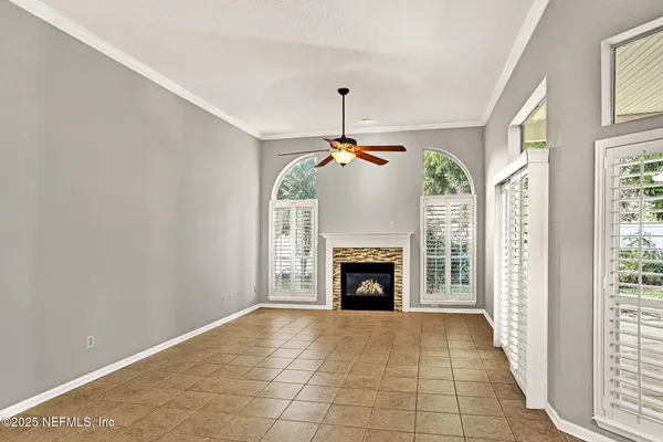 a view of an empty room with a fireplace and a window