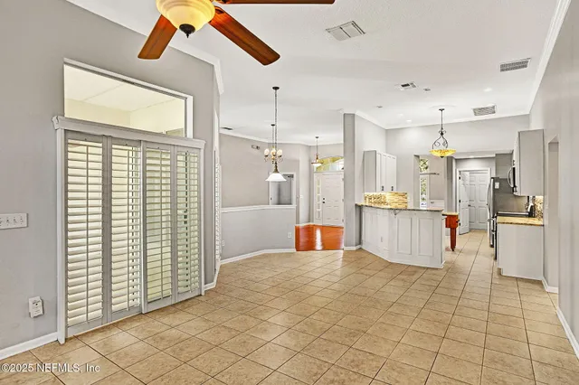 a kitchen with stainless steel appliances kitchen island granite countertop a refrigerator and white cabinets