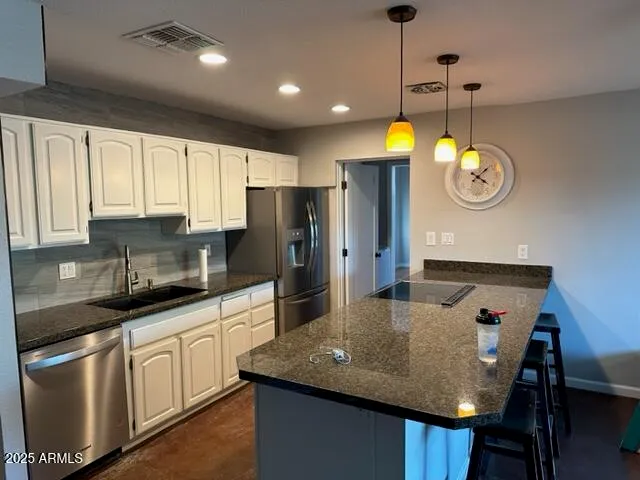 a kitchen with stainless steel appliances granite countertop a sink a microwave cabinets and a refrigerator