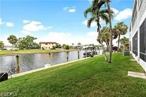 a view of a lake with a big yard and palm trees
