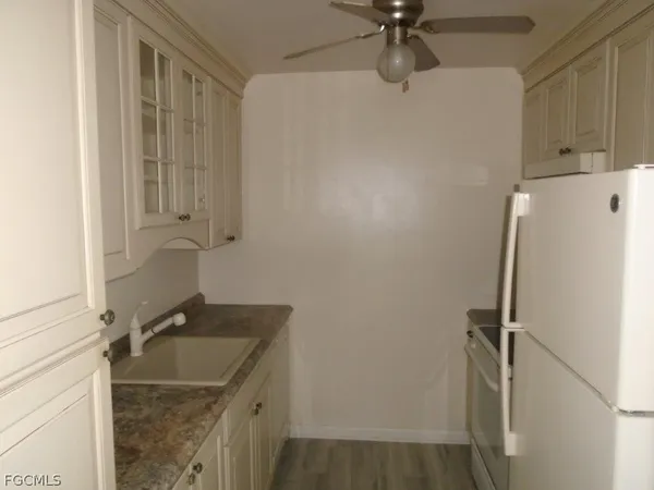 a bathroom with a granite countertop sink vanity and shower