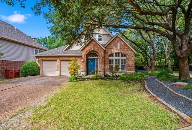 a front view of a house with yard and green space