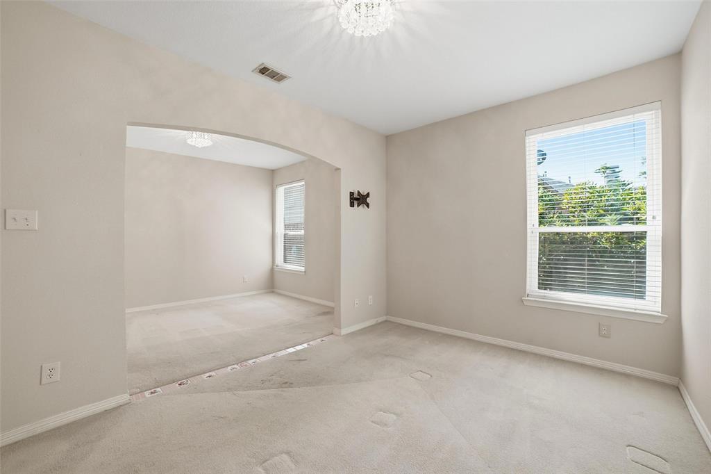 7909 Enclave Way Dallas, TX 75218 - Photo 15 of 21 Unfurnished room featuring carpet floors, arched walkways, and a chandelier