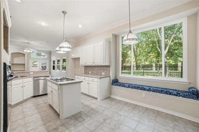 a large kitchen with kitchen island a large counter space a sink appliances and cabinets