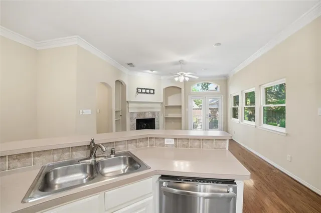 a kitchen with stainless steel appliances granite countertop a sink and a stove next to a large window