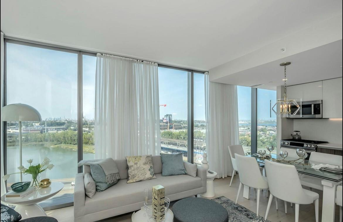 131-01 40 Road, Unit 11N Queens, NY 11354 - Photo 6 of 18 Living area featuring expansive windows, a chandelier, a view of city, and light wood finished floors