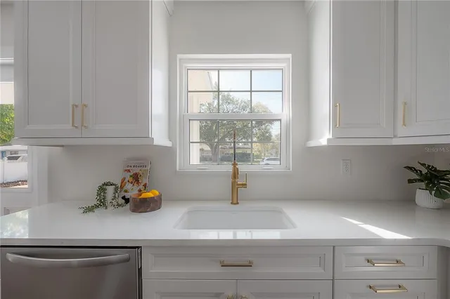 a kitchen with stainless steel appliances white cabinets and a window