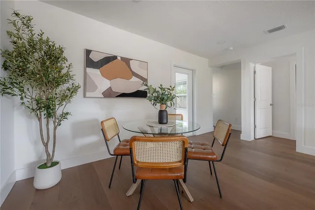 a dining room with furniture potted plants and wooden floor