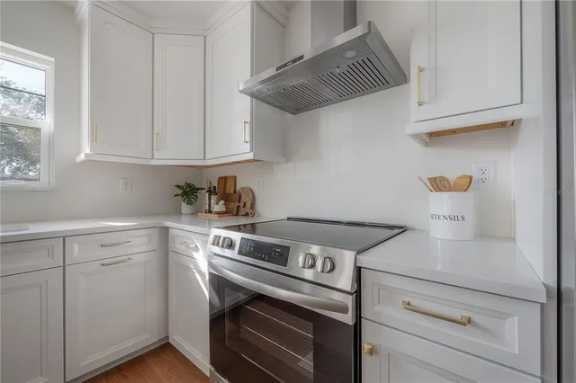 a kitchen with a stove and white cabinets
