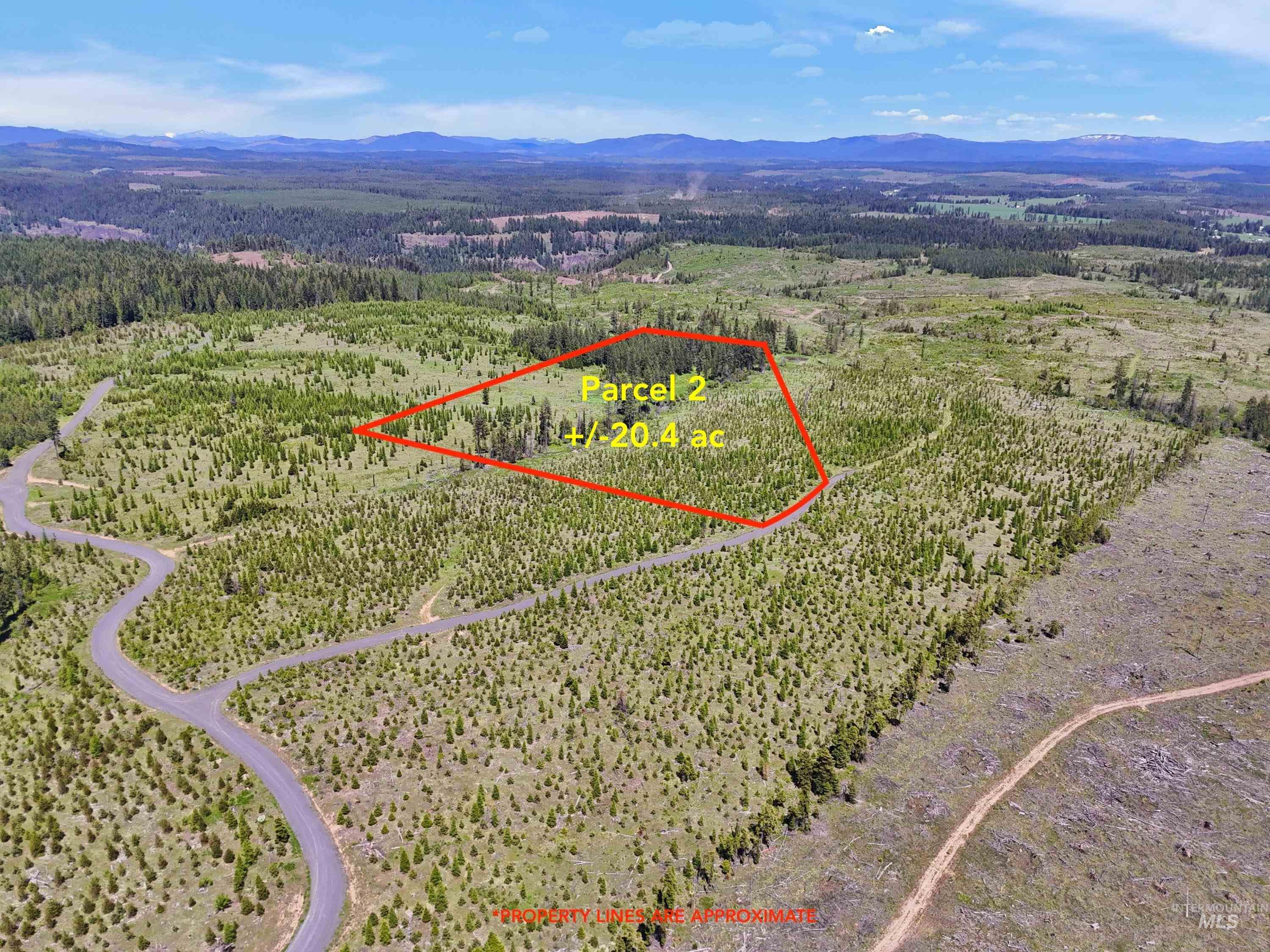 Aerial view of property's location with a mountainous background and property parcel outlined