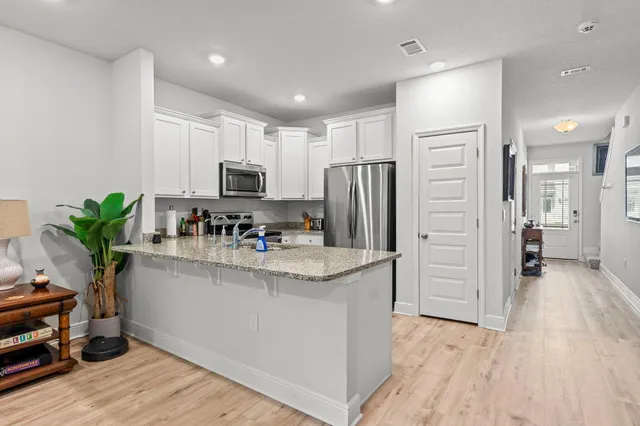 a kitchen with stainless steel appliances kitchen island granite countertop a refrigerator and a stove top oven