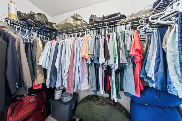 a view of walk in closet with clothes