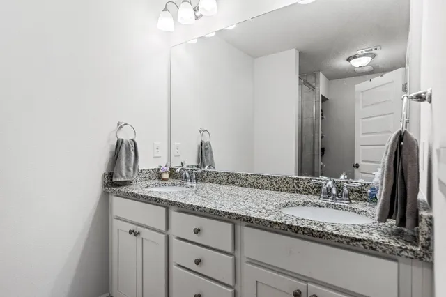 a bathroom with a granite countertop sink and a mirror