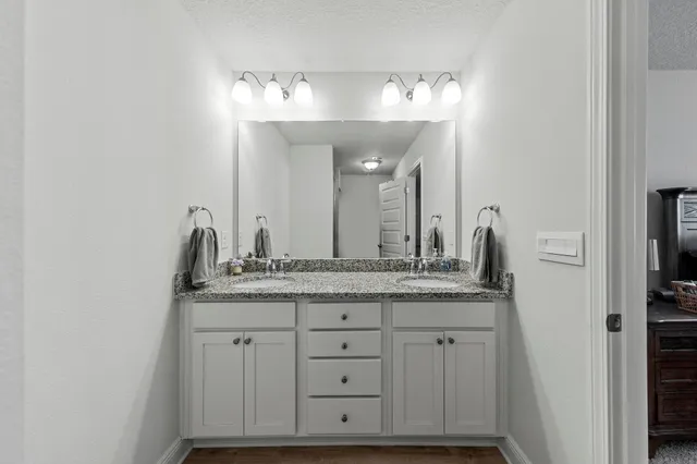 a bathroom with a granite countertop sink and a mirror