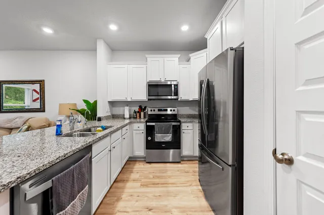 a kitchen with granite countertop a refrigerator and a sink