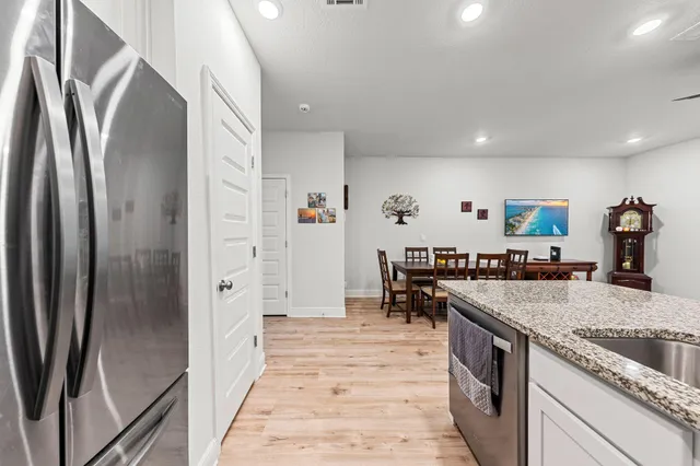 a kitchen with stainless steel appliances granite countertop a refrigerator and a sink