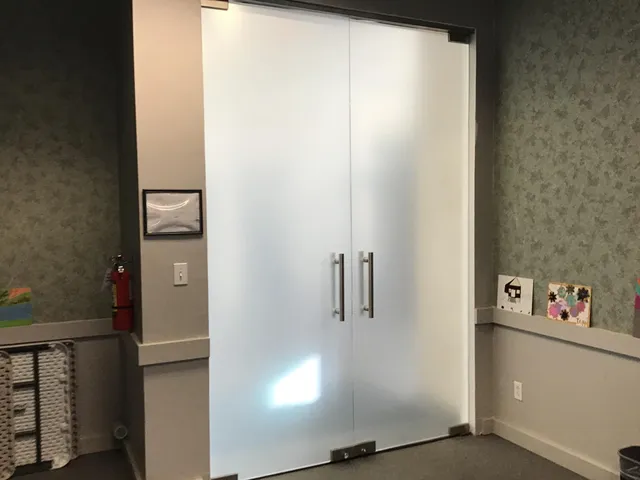 a large white kitchen with cabinets a sink a window and a refrigerator