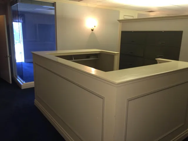 an empty room with wooden floor and windows with curtains