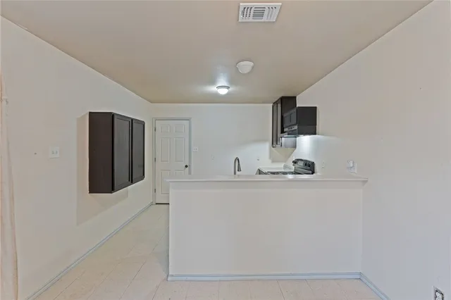 a view of kitchen with stainless steel appliances wooden floor and window