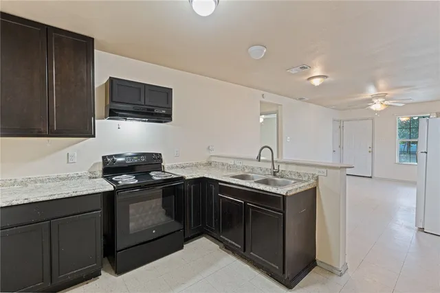 a kitchen with stainless steel appliances granite countertop a sink stove and microwave