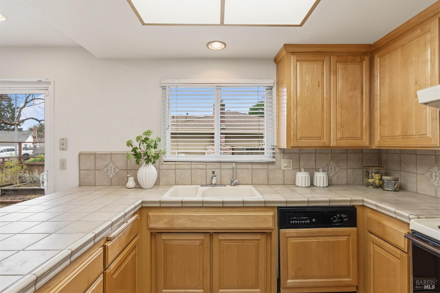 1808 Sherwood Court Santa Rosa, CA 95405 - Photo 11 of 30 a kitchen with granite countertop a sink and a white wooden cabinets