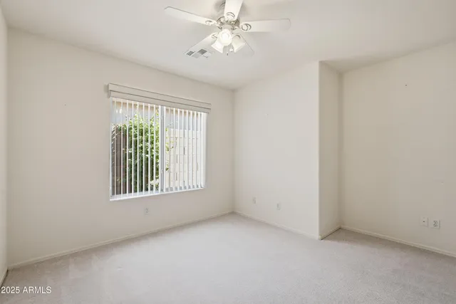 an empty room with fan and entrance