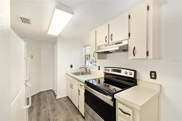 a kitchen with a refrigerator stove and white cabinets