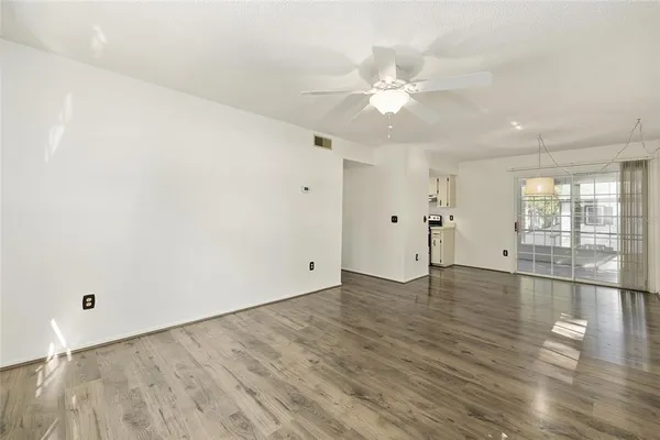 an empty room with wooden floor and windows