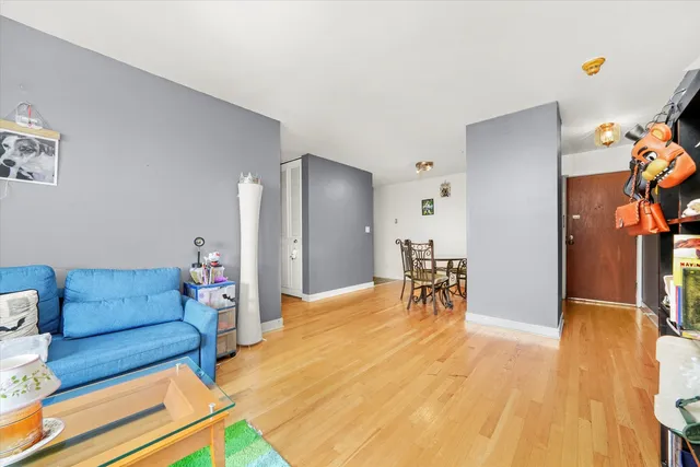 a living room with furniture and a dining table with wooden floor