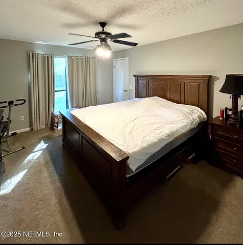 a spacious bedroom with a bed and a chandelier
