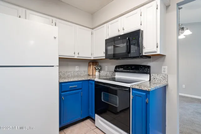a kitchen with stainless steel appliances granite countertop a stove a microwave and a refrigerator