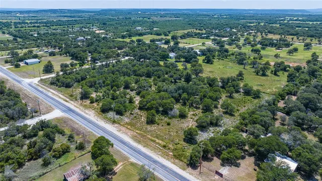 an aerial view of residential houses with outdoor space and trees