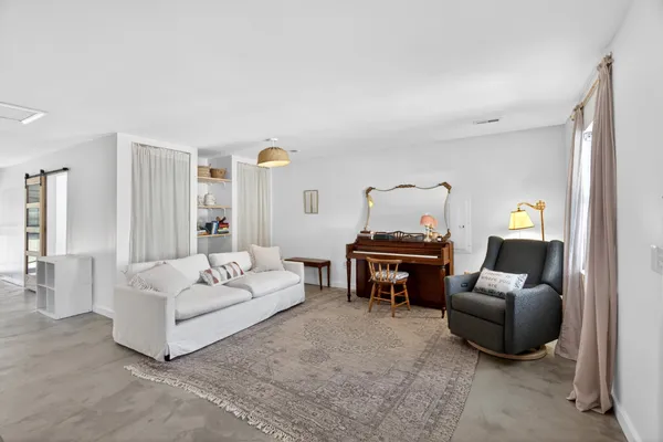 a living room with furniture and a piano