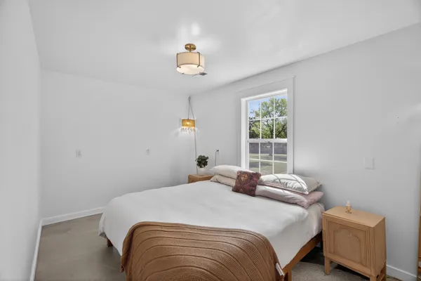 a bedroom with a bed and a window