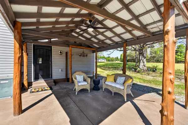 a view of living room with patio furniture and floor to ceiling window