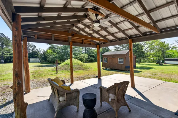 a view of a patio with a table chairs and a backyard