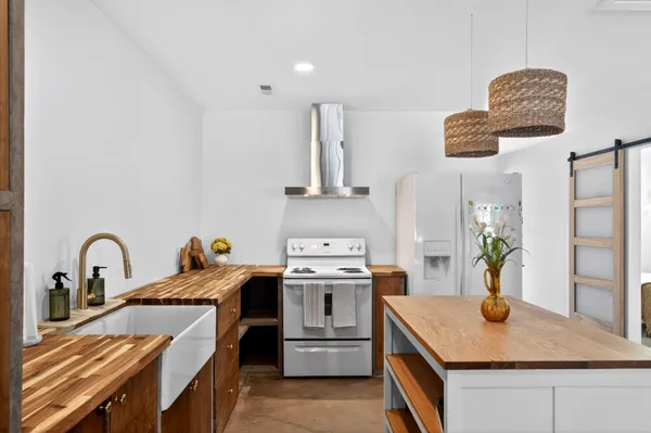 a kitchen with stainless steel appliances granite countertop a stove a sink and a refrigerator