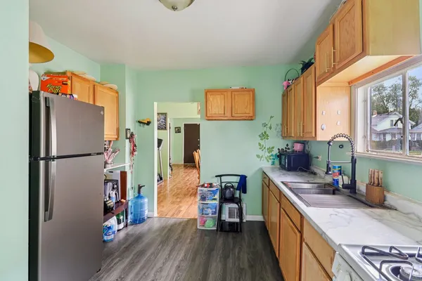 a kitchen with stainless steel appliances a refrigerator and a wooden floor