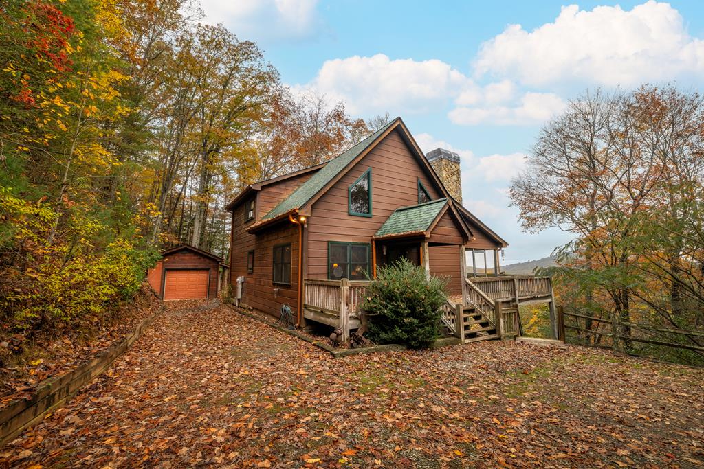 a front view of a house with a yard and large tree